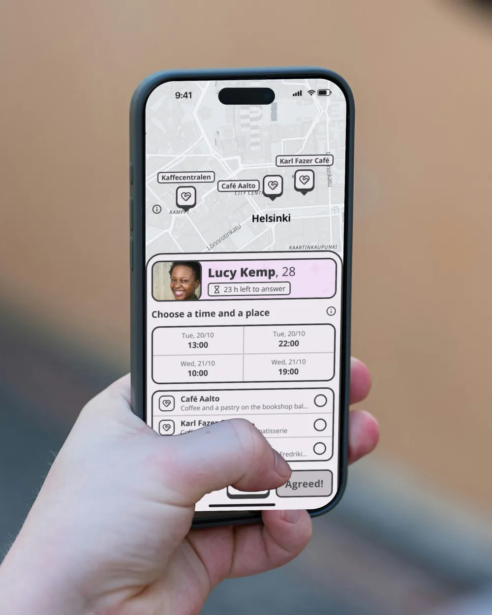 A phone held up in front of a peach-coloured house, showing a date invitation received: who sent it, the times and the places.